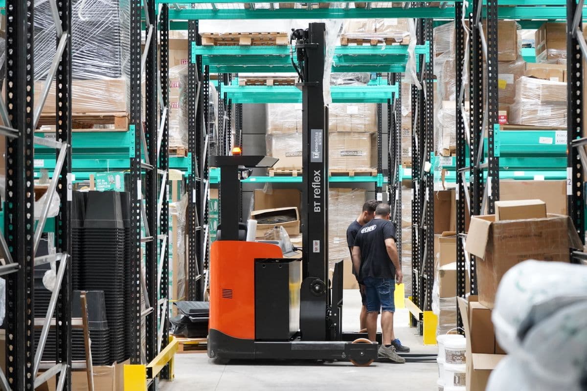 Warehouse worker operating a reach truck in a distribution centre